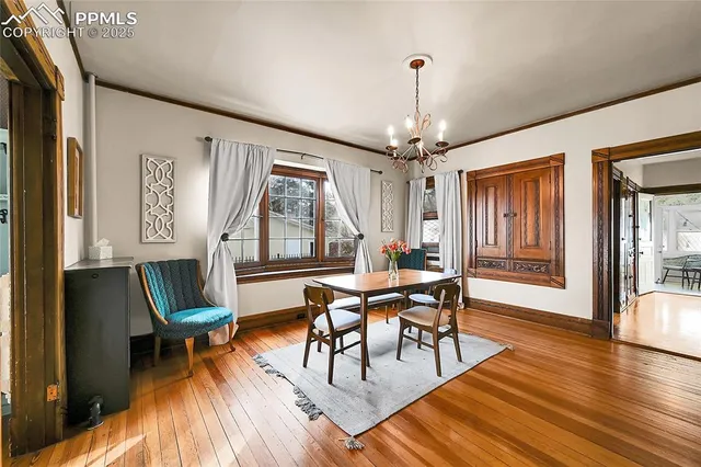 a dining room with furniture a chandelier and wooden floor