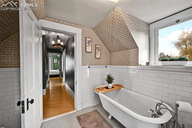 a bathroom with a tub a sink and a window