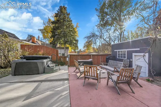 a view of a patio with table and chairs with wooden fence and plants