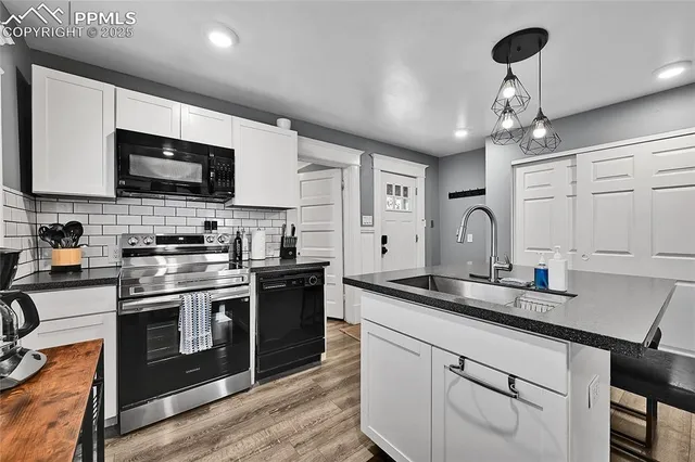 a kitchen with stainless steel appliances granite countertop a sink a stove and a microwave