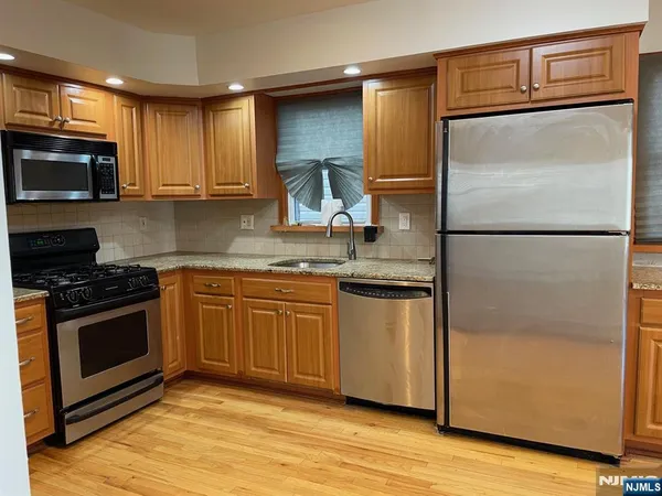 a kitchen with stainless steel appliances granite countertop a refrigerator stove and microwave