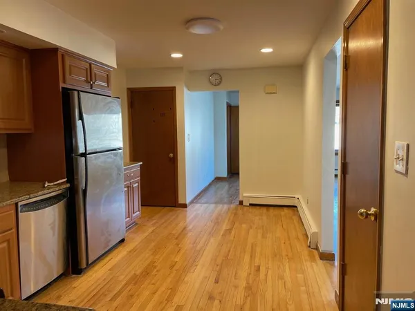 a view of a refrigerator in kitchen and wooden floor