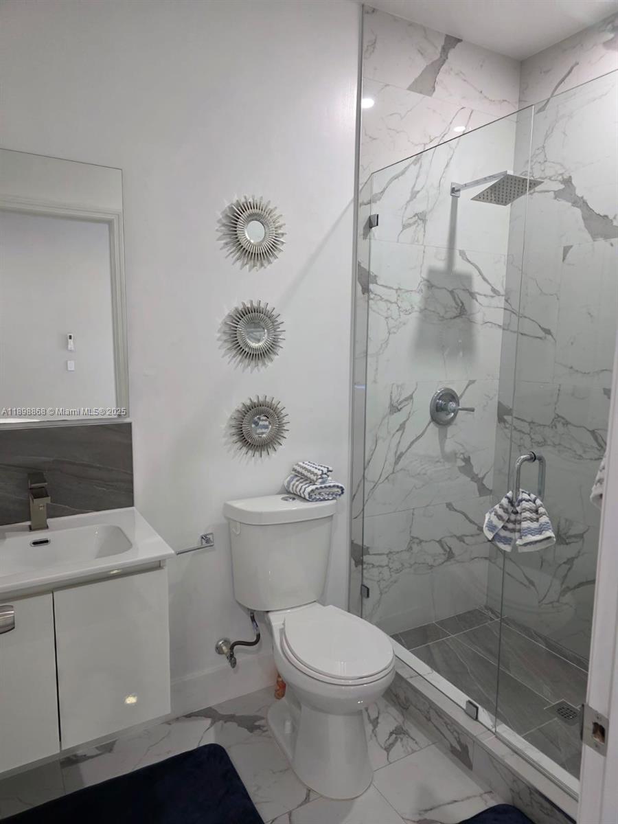 13995 Southwest 154th Street, Unit 2 Miami, FL 33177 - Photo 5 of 11 a bathroom with a toilet sink and shower