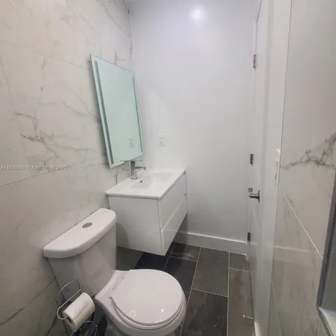 a white toilet sitting next to a bathroom sink