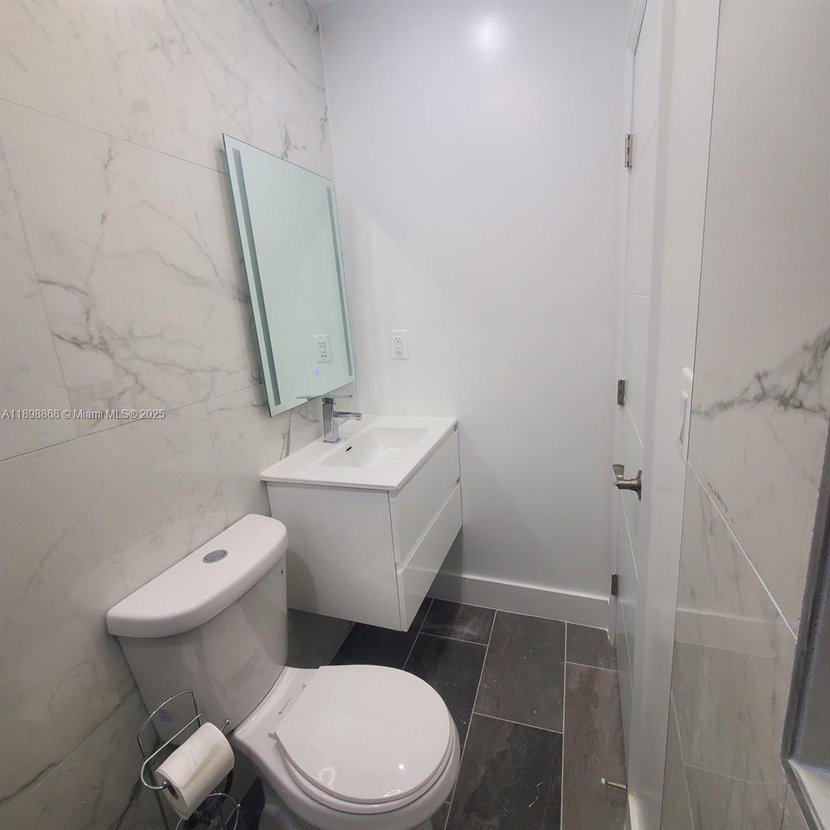 13995 Southwest 154th Street, Unit 2 Miami, FL 33177 - Photo 8 of 11 a white toilet sitting next to a bathroom sink