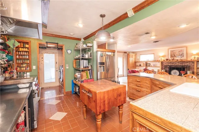 a living room with stainless steel appliances lots of furniture and chandelier