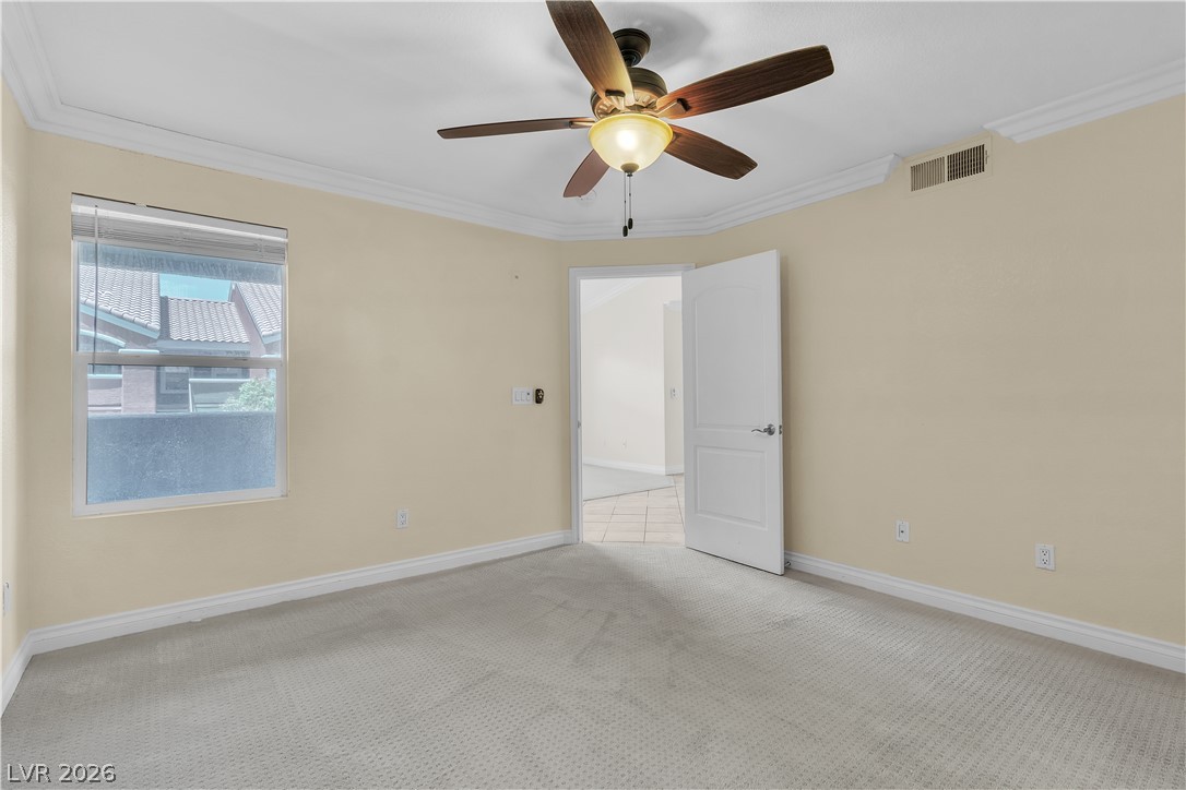 8101 West Flamingo Road, Unit 2001 Las Vegas, NV 89147 - Photo 11 of 28 A comfortable bedroom with carpeted flooring and a modern ceiling fan for optimal airflow.