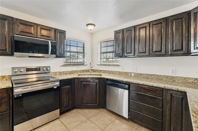 a kitchen with granite countertop cabinets stainless steel appliances and a window