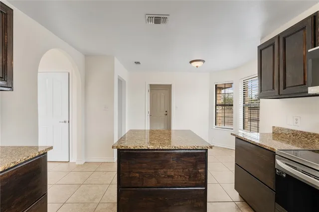 a kitchen with granite countertop a sink and a stove