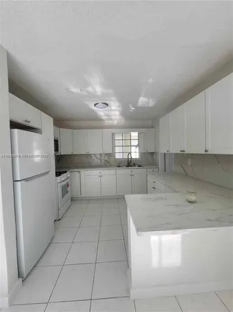 a kitchen with stainless steel appliances granite countertop a refrigerator sink and cabinets