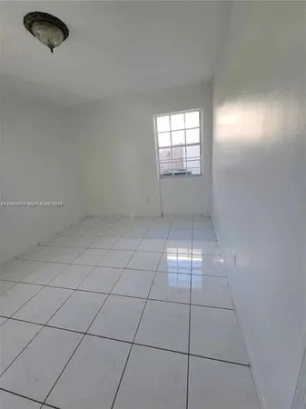a view of an empty room and chandelier fan