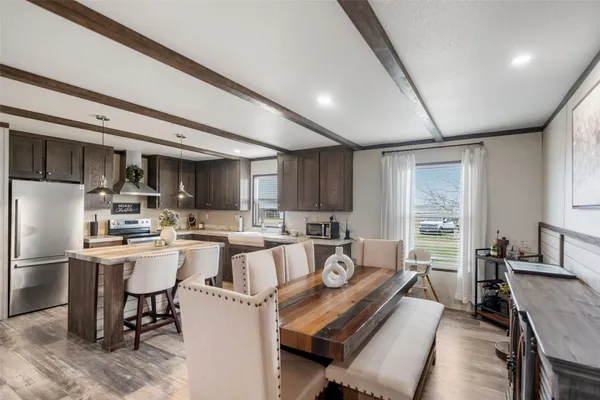 a kitchen with refrigerator a sink and chairs