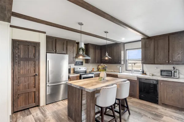 a kitchen with stainless steel appliances granite countertop a stove and a wooden floors