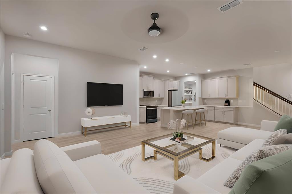 19431 Monarch Wind Way Lutz, FL 33558 - Photo 2 of 17 a living room with furniture a flat screen tv and kitchen view