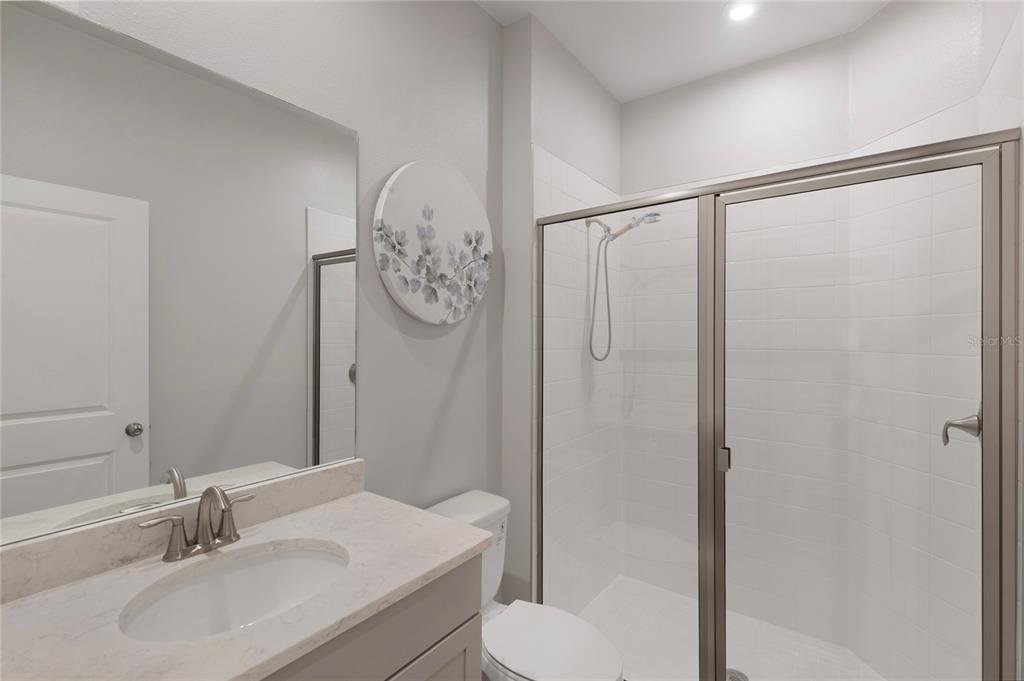 19431 Monarch Wind Way Lutz, FL 33558 - Photo 5 of 17 a bathroom with a sink a toilet and shower