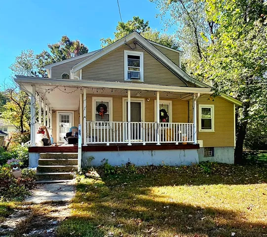a front view of a house with a yard outdoor seating and mountain view