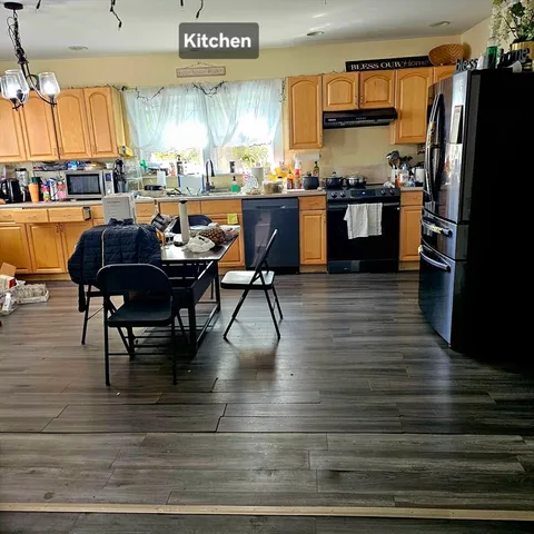 a kitchen with stainless steel appliances granite countertop a table chairs stove and refrigerator
