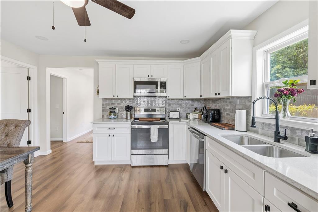 156 Pine Avenue Commerce, GA 30529 - Photo 17 of 35 a kitchen with a sink white cabinets and white appliances
