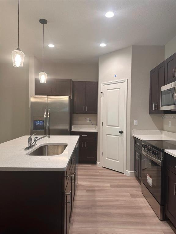 1575 South Montgomery Street DeLand, FL 32720 - Photo 2 of 12 a kitchen with a sink dishwasher a stove and a refrigerator with wooden floor