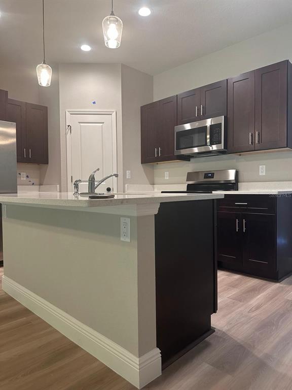 1575 South Montgomery Street DeLand, FL 32720 - Photo 3 of 12 a kitchen with stainless steel appliances granite countertop a sink a stove a refrigerator and a oven with wooden floor