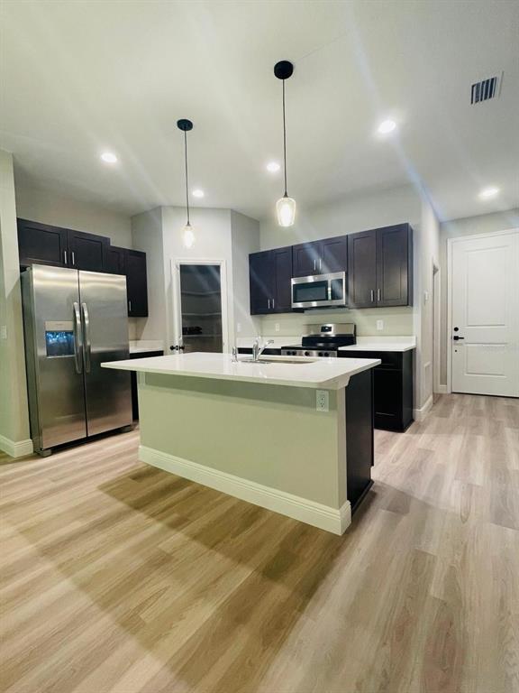 1575 South Montgomery Street DeLand, FL 32720 - Photo 5 of 12 a kitchen with kitchen island a sink stainless steel appliances and cabinets