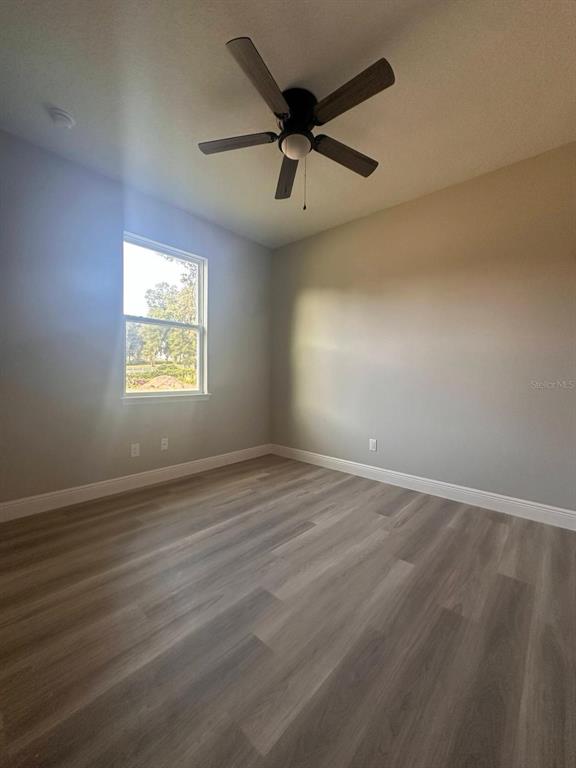 1575 South Montgomery Street DeLand, FL 32720 - Photo 6 of 12 an empty room with wooden floor and windows
