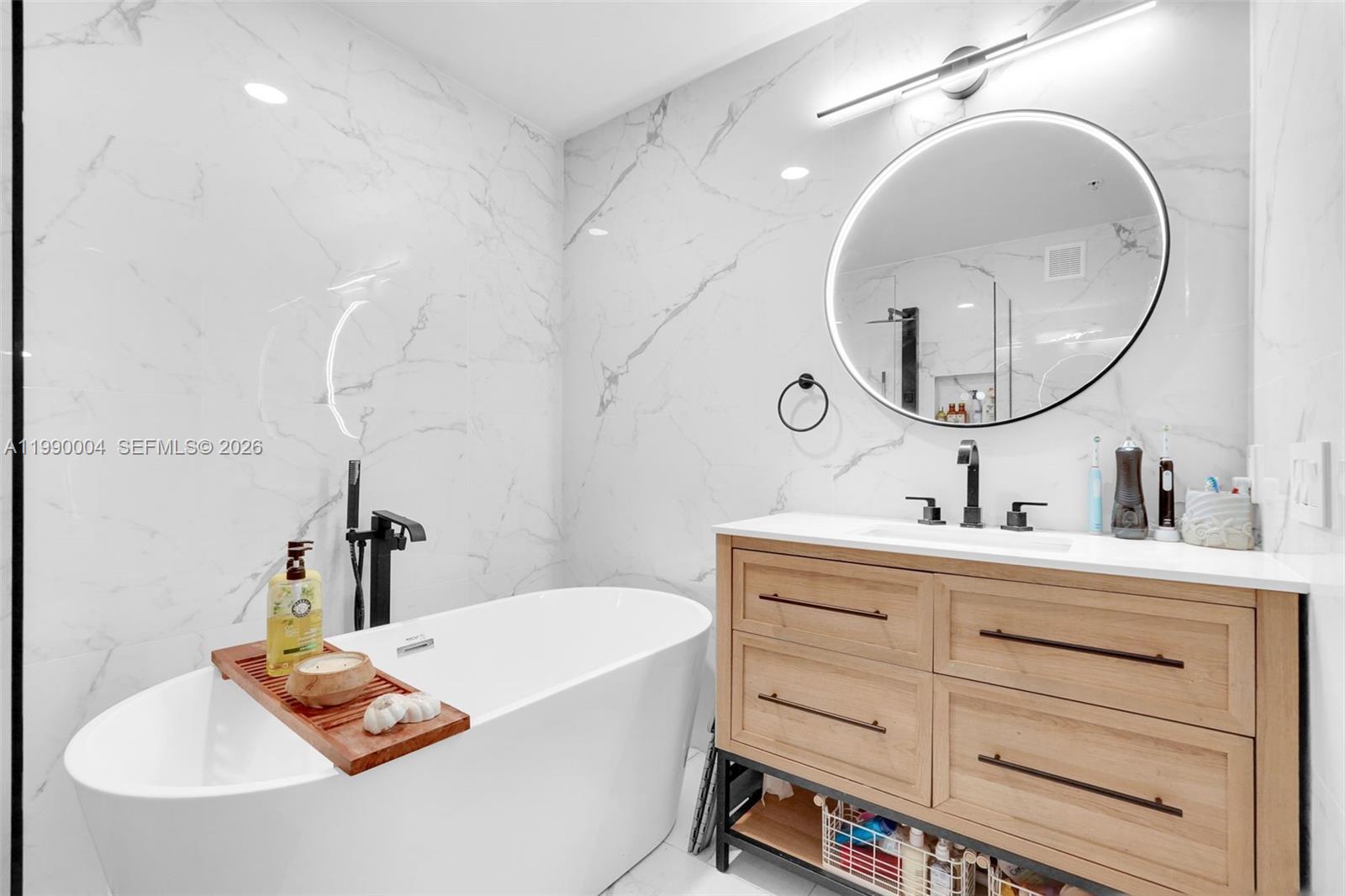 738 Northeast 90th Street, Unit 207 Miami, FL 33138 - Photo 11 of 31 a bathroom with a tub sink and mirror