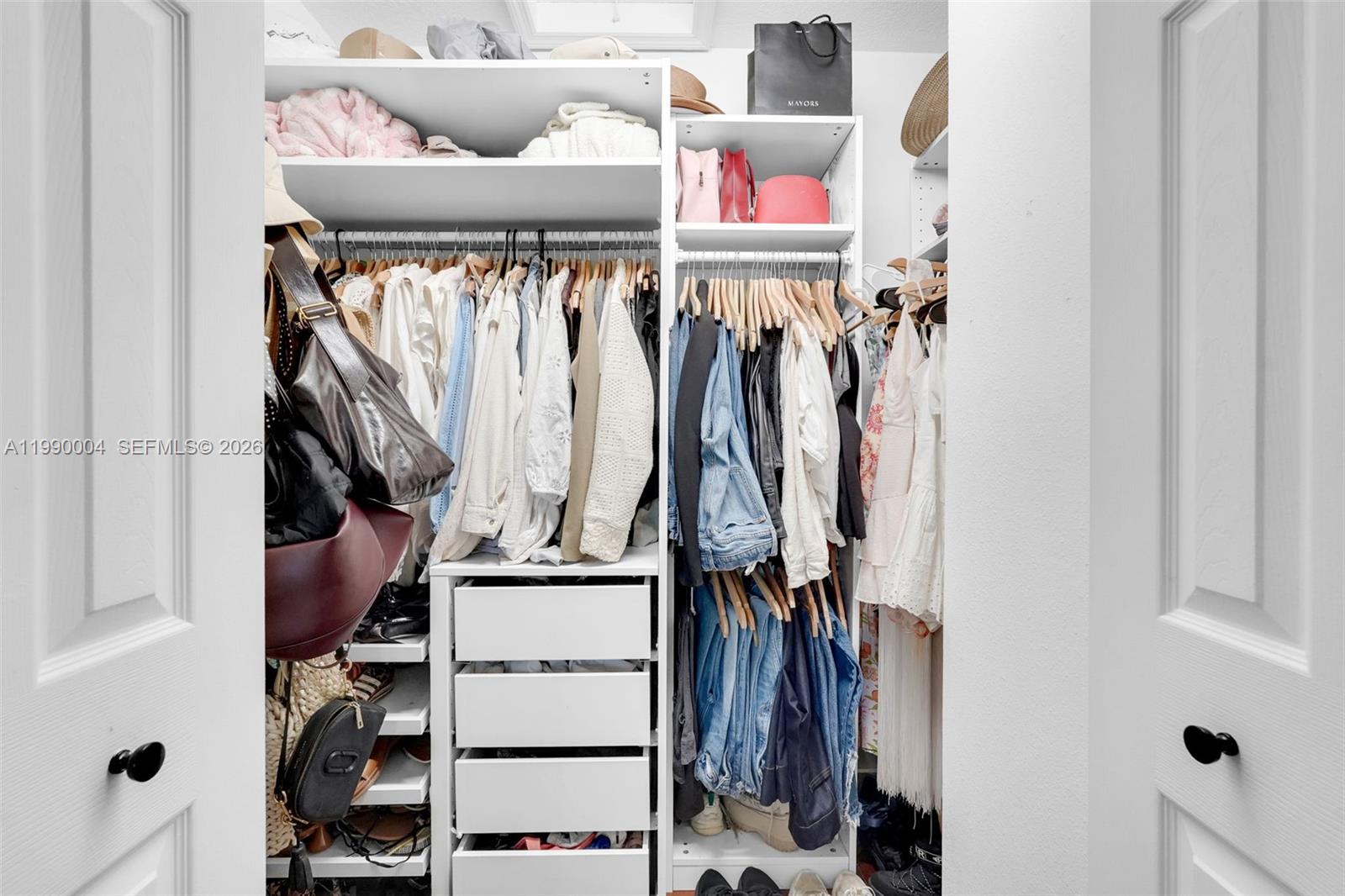 738 Northeast 90th Street, Unit 207 Miami, FL 33138 - Photo 15 of 31 a view of walk in closet with clothes and shoes