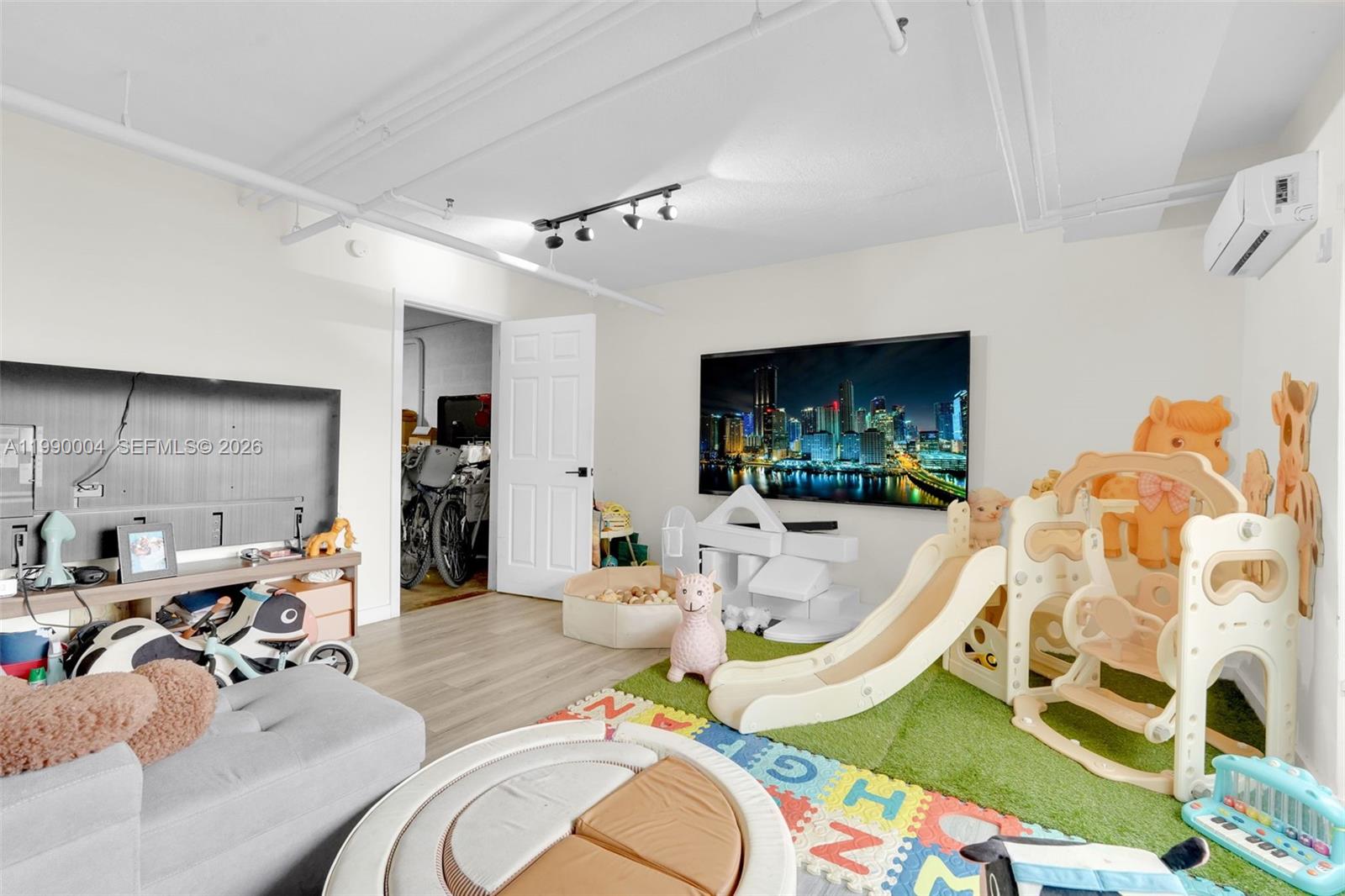 738 Northeast 90th Street, Unit 207 Miami, FL 33138 - Photo 23 of 31 a living room with furniture and a flat screen tv