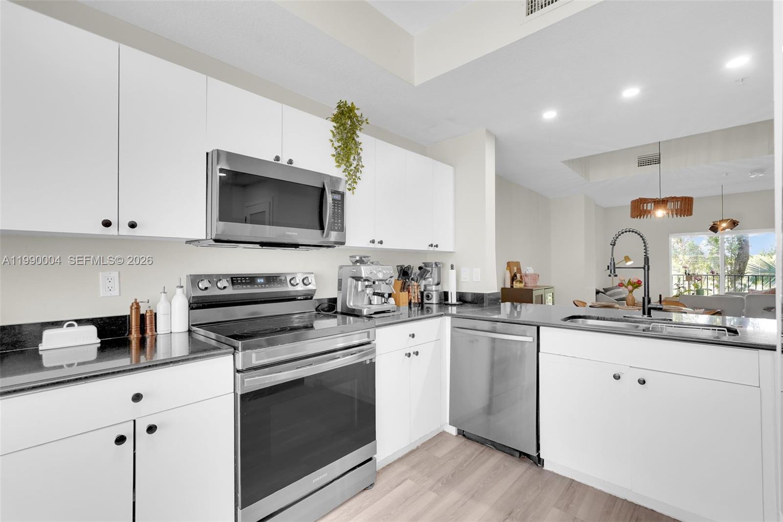 738 Northeast 90th Street, Unit 207 Miami, FL 33138 - Photo 7 of 31 a kitchen with a sink stove top oven and microwave