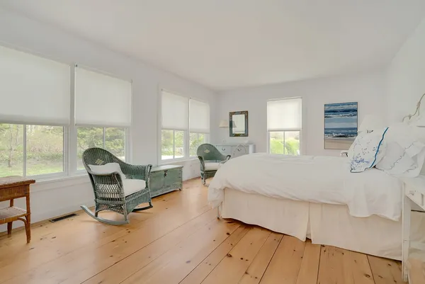 a bedroom with a bed chair and window
