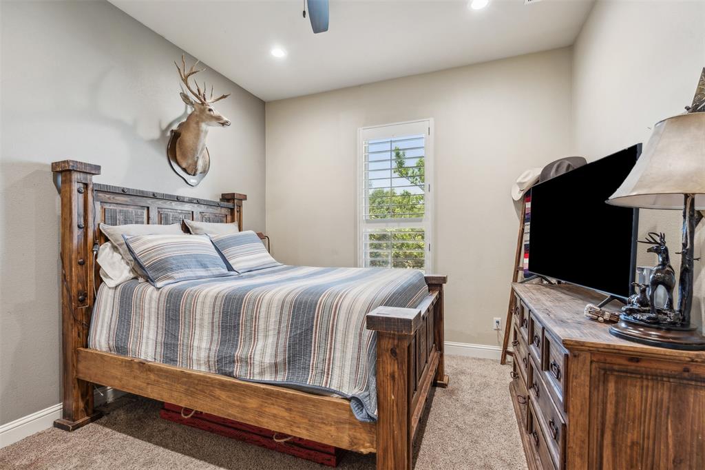 4180 North Smith Road Fate, TX 75087 - Photo 22 of 27 a bedroom with a bed a flat tv screen and a dresser