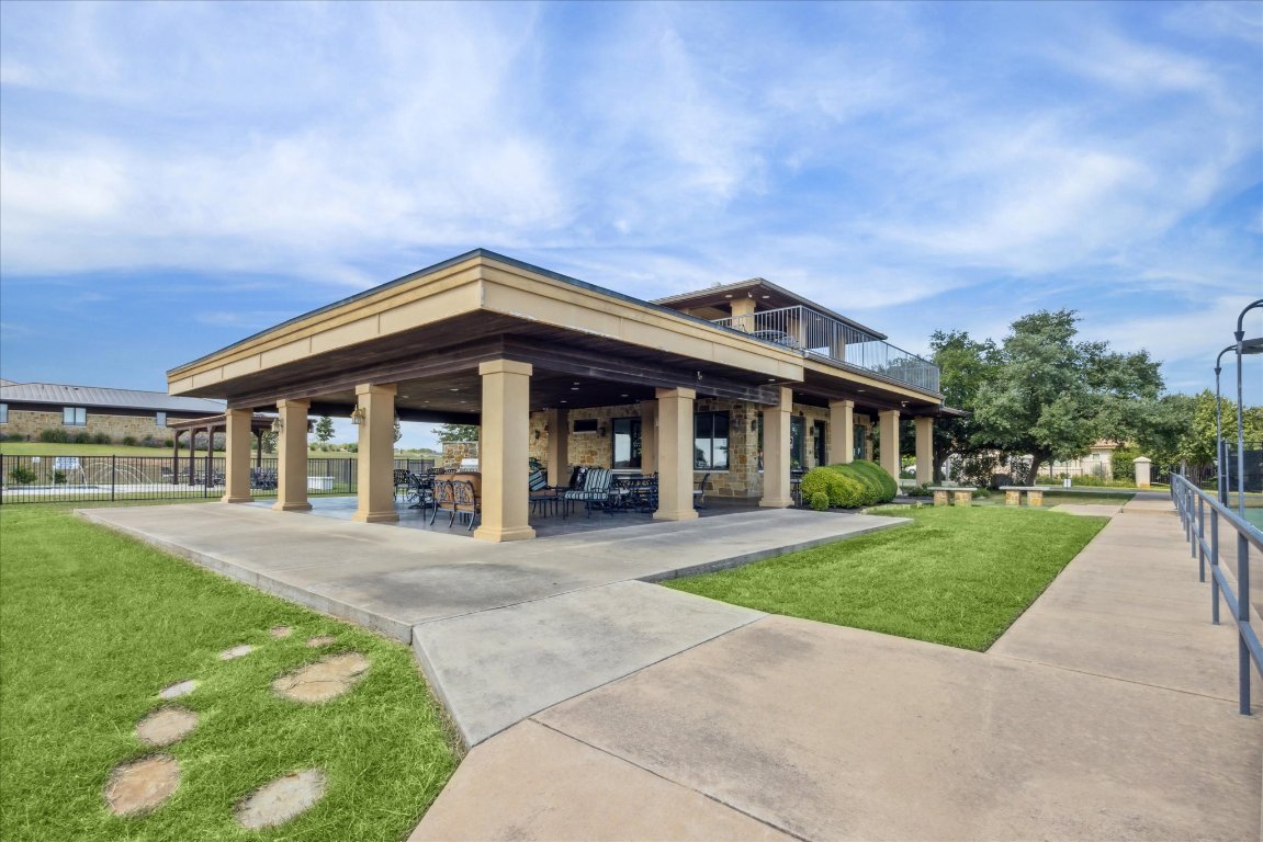25409 Cliff Crossing Spicewood, TX 78669 - Photo 9 of 11 a front view of a house with a yard table and chairs