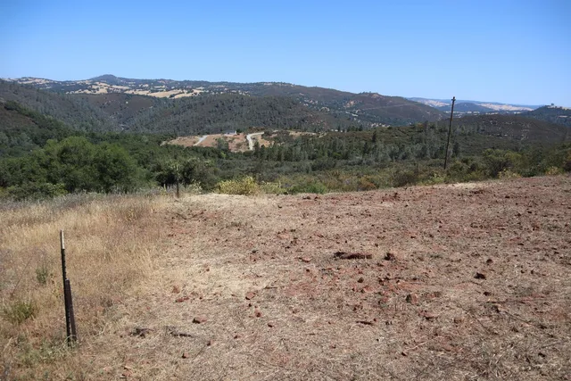 a view of a dry yard with mountains in the background