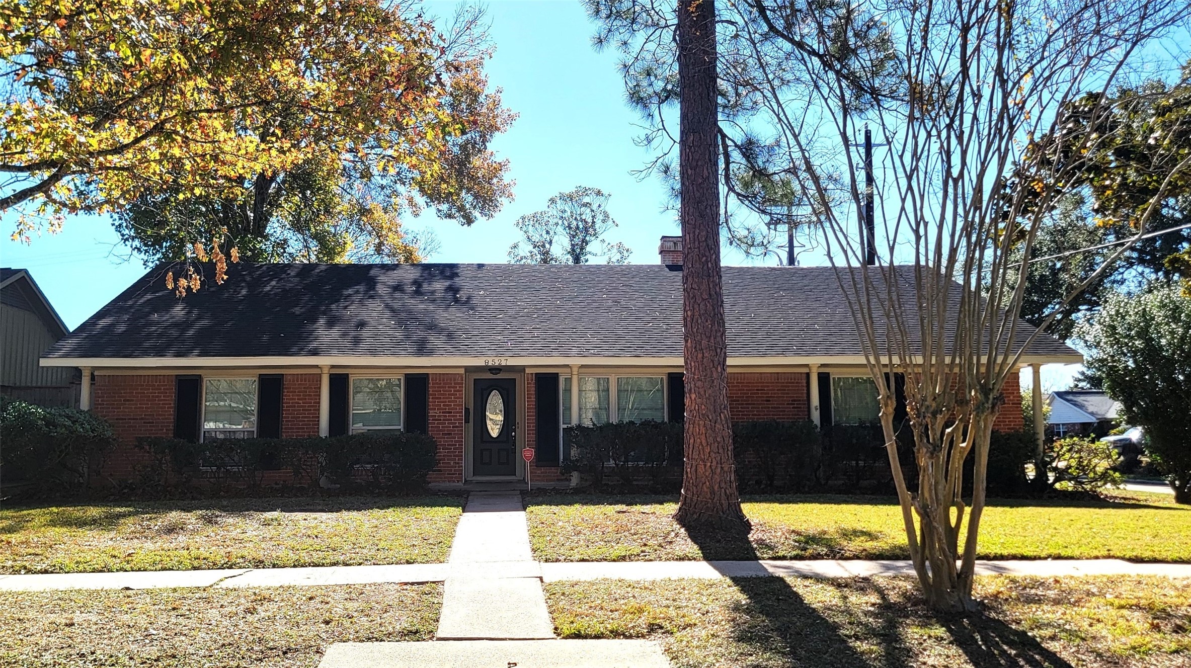 a view of house with a yard in the background