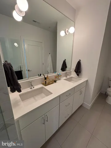 a bathroom with a double vanity sink and a mirror