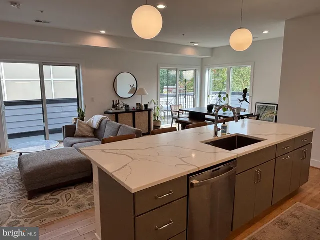a kitchen with sink and view of living room