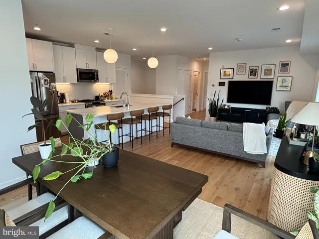 a living room with furniture a flat screen tv and kitchen view