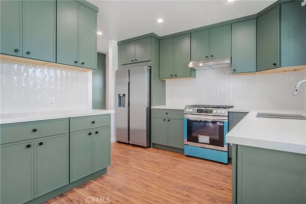 a kitchen with stainless steel appliances a refrigerator stove and sink
