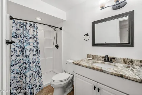 a bathroom with a granite countertop sink a toilet and a mirror