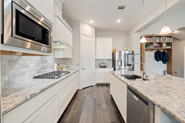 a large kitchen with kitchen island granite countertop a sink and cabinets