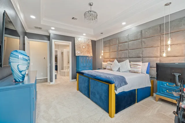 a spacious bedroom with a bed a table and potted plant