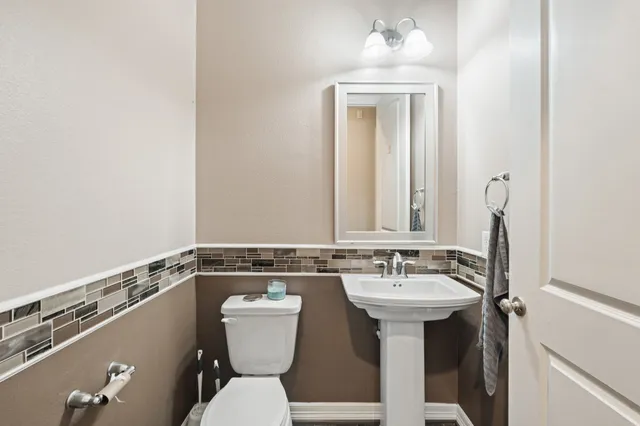 a bathroom with a sink mirror and toilet