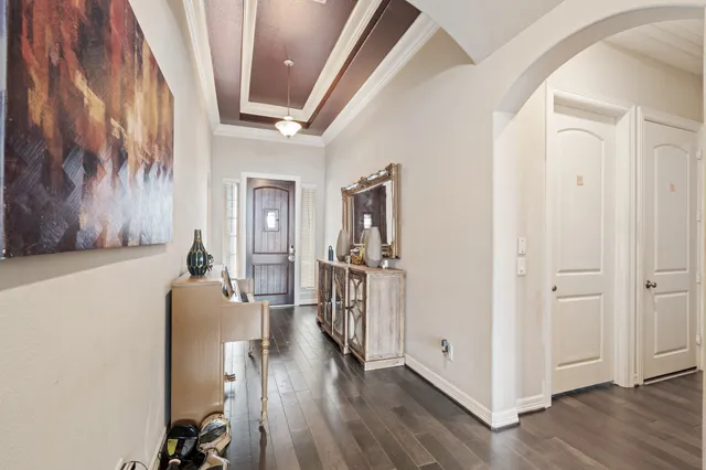 a hallway with wooden floor and furniture