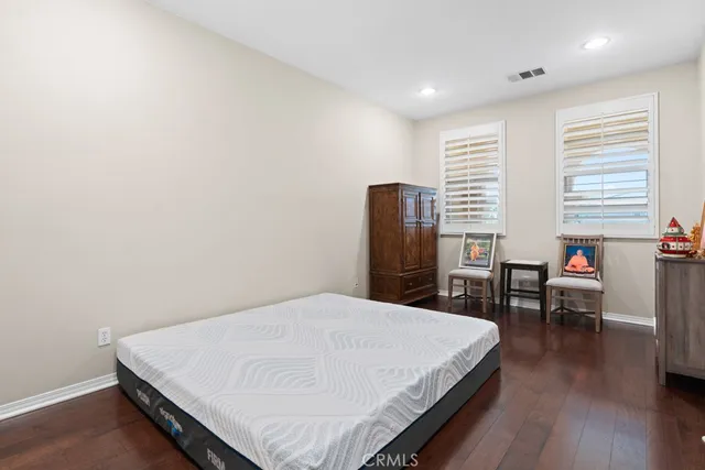 a bed sitting in a spacious bedroom next to a window