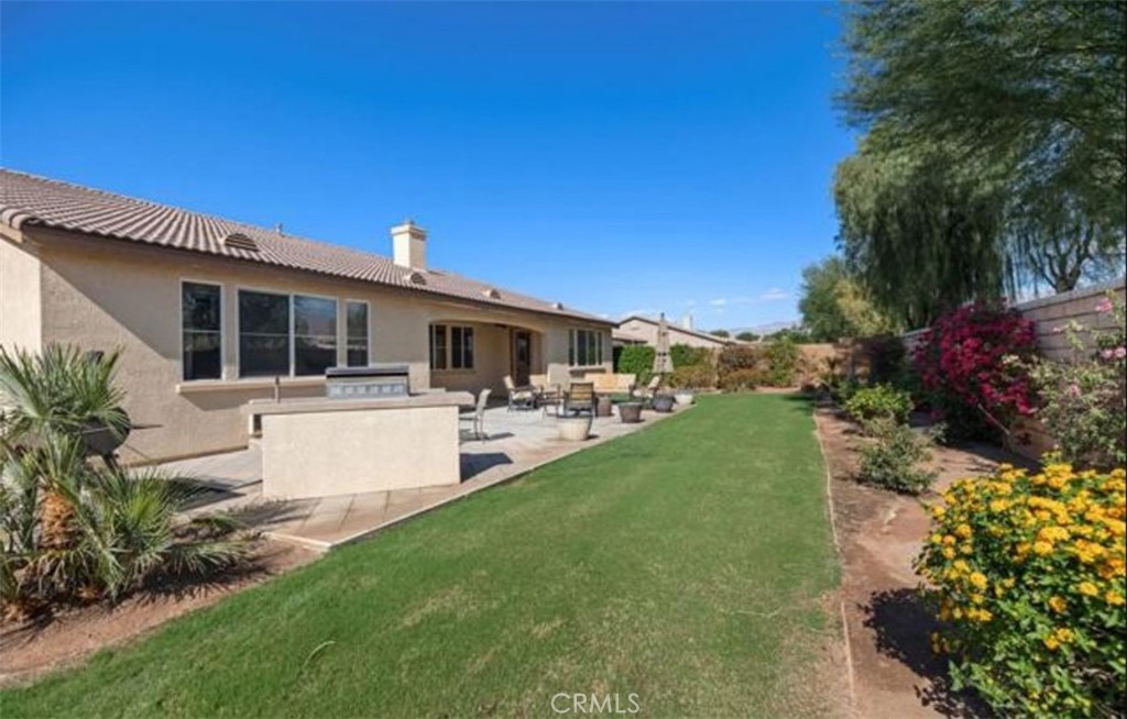 42914 Tomayo Street Indio, CA 92203 - Photo 29 of 31 a view of a white house with a big yard and potted plants