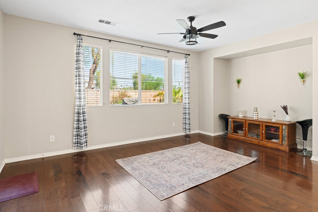 42914 Tomayo Street Indio, CA 92203 - Photo 10 of 31 an workspace with wooden floor a ceiling fan and a window