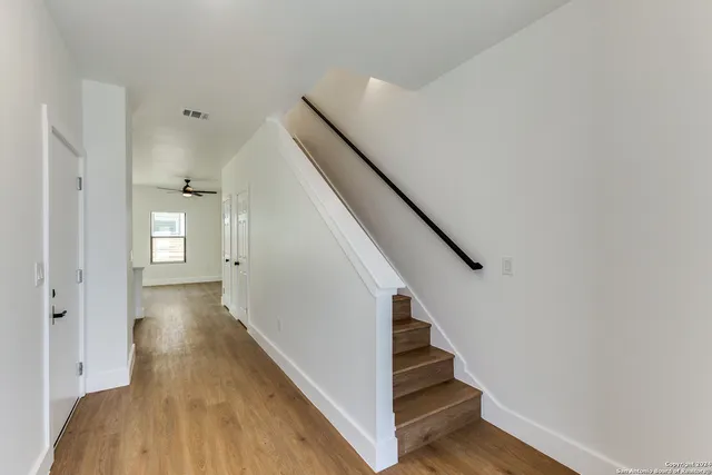 a view of a hallway with wooden floor and entryway