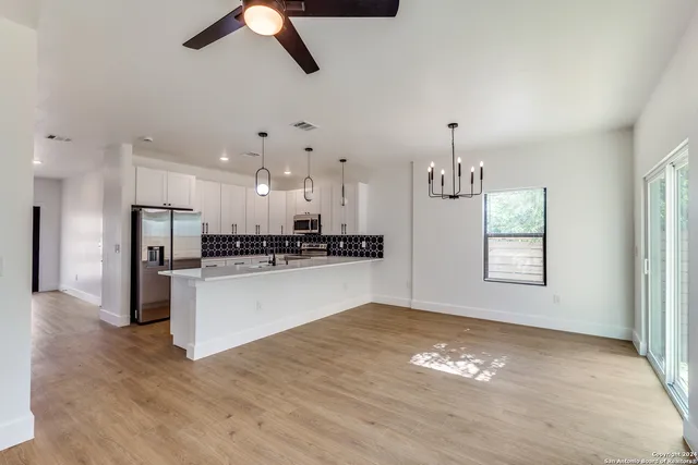 a view of kitchen with ceiling fan refrigerator and window