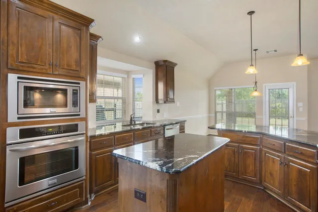 a kitchen that has a sink a stove and microwave